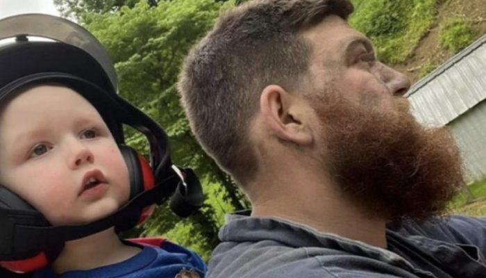 Miner brought his son to the game directly after work. He didn't even have time to change his clothes.